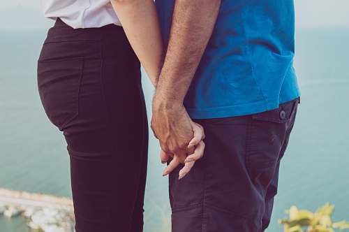 holding hands couple holding each other's hand near body of water human
